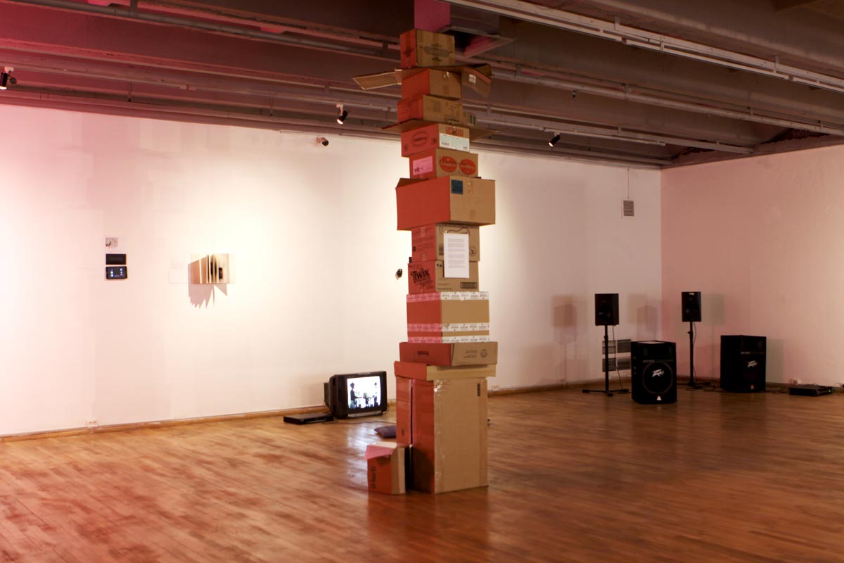 Cardboards collected and put together verticaly in the exhibition space.